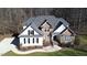 An aerial view of a house with stone and siding, a well-manicured lawn, and mature trees at 1201 Rivermead Ln, Wake Forest, NC 27587