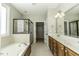 Bright bathroom with tub, glass-enclosed shower, double vanity, and access to a closet at 1201 Rivermead Ln, Wake Forest, NC 27587