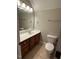 Bathroom with a large mirror above the vanity, wooden cabinets, and standard toilet at 1201 Rivermead Ln, Wake Forest, NC 27587