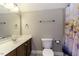 Neutral bathroom with a modern vanity, updated mirror, and shower with colorful curtain at 1201 Rivermead Ln, Wake Forest, NC 27587