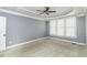 Spacious bedroom featuring tray ceilings, a ceiling fan, and large window with blinds, plus neutral carpeting at 1201 Rivermead Ln, Wake Forest, NC 27587