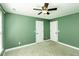 Bedroom with green walls, white trim, neutral carpet, ceiling fan, and two doors at 1201 Rivermead Ln, Wake Forest, NC 27587