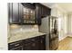 Modern kitchen featuring granite countertops, stainless steel refrigerator, and dark cabinets at 1201 Rivermead Ln, Wake Forest, NC 27587