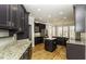 Modern kitchen with dark cabinets, granite countertops, an island, stainless steel appliances, and hardwood floors at 1201 Rivermead Ln, Wake Forest, NC 27587