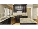 Elegant kitchen with dark cabinets, granite countertops, stainless steel appliances, and a tile backsplash at 1201 Rivermead Ln, Wake Forest, NC 27587