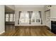 Sunlit living room with hardwood floors, fireplace, built-in cabinets, and a view of the backyard through large windows at 1201 Rivermead Ln, Wake Forest, NC 27587