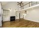 Open-concept living room with hardwood floors, a fireplace, and a soaring ceiling with a ceiling fan and upstairs balcony at 1201 Rivermead Ln, Wake Forest, NC 27587