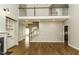 Spacious living room with hardwood floors, fireplace, built-in shelving, and an upstairs balcony at 1201 Rivermead Ln, Wake Forest, NC 27587