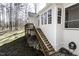 Exterior view of home with an elevated back porch and wood stairs descending to the backyard at 1201 Rivermead Ln, Wake Forest, NC 27587