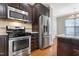 Kitchen with stainless steel appliances and dark wood cabinets at 1256 Silver Beach Way, Raleigh, NC 27606