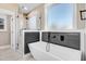 Modern bathroom with soaking tub and gray plank accent wall at 1647 Old Dam Rd, Kenly, NC 27542