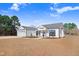 White two-story house with gray roof, large windows, and landscaping at 1647 Old Dam Rd, Kenly, NC 27542