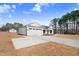 White house with three car garage and large driveway at 1647 Old Dam Rd, Kenly, NC 27542