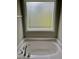 Bathroom featuring a large garden tub and a window providing natural light at 166 Gulley Glen Dr, Garner, NC 27529