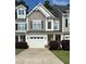 Two-story townhome with gray siding, white garage door, and landscaping at 166 Gulley Glen Dr, Garner, NC 27529