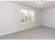 An airy bedroom with a window, neutral walls, plush carpet, ceiling light and crisp white trim at 237 Hopewell Branch Ct, Smithfield, NC 27577