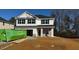 Two-story house with white siding and stone accents, a large yard, and a dumpster at 237 Hopewell Branch Ct, Smithfield, NC 27577