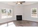 Living room with a cozy fireplace, ceiling fan, and large windows offering plenty of natural light at 237 Hopewell Branch Ct, Smithfield, NC 27577