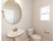 Bright powder room featuring a pedestal sink, round mirror, and natural light at 237 Hopewell Branch Ct, Smithfield, NC 27577