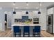 Modern kitchen with white cabinets, blue tile backsplash, and large island at 2515 Impulsion Dr, New Hill, NC 27562