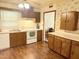 Traditional kitchen features wood cabinets, white appliances, and warm wood-look flooring at 2612 Academy St, Sanford, NC 27332