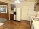 A traditional kitchen has wood look flooring, upper cabinets, and white appliances at 2612 Academy St, Sanford, NC 27332