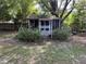 Exterior view of a small, screened pavilion surrounded by greenery at 2612 Academy St, Sanford, NC 27332