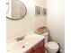 Bright bathroom featuring a stylish round mirror, modern vanity, and tasteful wall decor at 30 Cheltenham Dr, Clayton, NC 27520