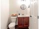 Cozy bathroom with a modern vanity, round mirror, and a toilet, exuding a clean and efficient design at 30 Cheltenham Dr, Clayton, NC 27520