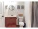 Bathroom with modern fixtures, including a wood vanity and a round mirror, enhanced by neutral decor at 30 Cheltenham Dr, Clayton, NC 27520