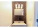 Stylish bathroom featuring modern fixtures, vanity mirror, and unique backsplash at 30 Cheltenham Dr, Clayton, NC 27520