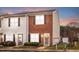 Charming townhouse featuring a brick facade, shutters, manicured landscaping, and well-maintained curb appeal at 30 Cheltenham Dr, Clayton, NC 27520