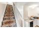 Stairway featuring a colorful stair runner and white railings adjacent to kitchen at 30 Cheltenham Dr, Clayton, NC 27520