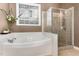 Bright bathroom featuring a soaking tub, glass shower, and a window offering natural light at 3905 Song Sparrow Dr, Wake Forest, NC 27587