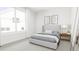 Bright bedroom with gray upholstered bed and large window at 4081 Elk Creek Ln # 07, Raleigh, NC 27612