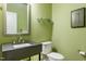 Small powder room with a gray sink, white toilet and green walls at 469 Triumph Ln, Wake Forest, NC 27587