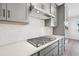 Close-up of a kitchen with stainless steel range hood and a white backsplash at 515 Wendover Pkwy, Pittsboro, NC 27312