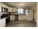 Modern kitchen with white cabinets, stainless steel appliances, and granite countertops at 516 S Flanner St, Burlington, NC 27215