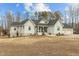 Charming home boasts board and batten siding, a covered front porch, and an attached three-car garage at 65 Soggy Bottom Trl, Zebulon, NC 27597