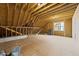 Unfinished attic space with exposed wood beams, a window, and natural light at 8001 Wexford Waters Ln, Wake Forest, NC 27587