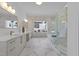 Luxury bathroom featuring marble floors, double vanities, soaking tub and a glass-enclosed shower at 8001 Wexford Waters Ln, Wake Forest, NC 27587