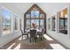 Bright dining room featuring large windows, wood accent wall, modern lighting and round table at 8001 Wexford Waters Ln, Wake Forest, NC 27587