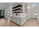 Modern kitchen with white cabinets, quartz countertops, and unique shelving at 8001 Wexford Waters Ln, Wake Forest, NC 27587