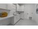 Bright laundry room featuring white cabinets, countertop space, and a stainless-steel sink at 8001 Wexford Waters Ln, Wake Forest, NC 27587