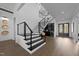 Elegant staircase with modern black and metal railings, hardwood floors, and a stylish foyer at 8001 Wexford Waters Ln, Wake Forest, NC 27587
