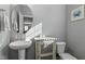 Powder room with pedestal sink, decorative cabinet, and neutral color palette at 105 Langdon Chase Way, Selma, NC 27576