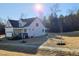 A new white home with a two-car garage, stone accents, and a covered porch stands in the sun at 1116 Prominence Dr., Homesite 31, Durham, NC 27712
