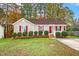 Tan house with red shutters, landscaping, and a red front door at 125 Havencrest Lndg, Garner, NC 27529