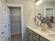 A well-lit bathroom features a dual sink vanity with quartz countertop and walk in closet at 1364 Barreto Dr, Wendell, NC 27591