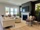 Cozy living room with a fireplace, large windows, comfortable seating, and a neutral color palette at 1364 Barreto Dr, Wendell, NC 27591